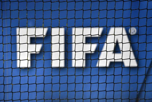 (FILES) The logo of FIFA (Federation Internationale de Football Association) is seen through a net on October 13, 2016 at the world football's governing body headquarters in Zurich. FIFA president Gianni Infantino came under renewed fire on August 10, 2026 as a joint letter from three confederations -- UEFA, CONCACAF and AFC -- declared football "belongs to no individual". (Photo by FABRICE COFFRINI / AFP)