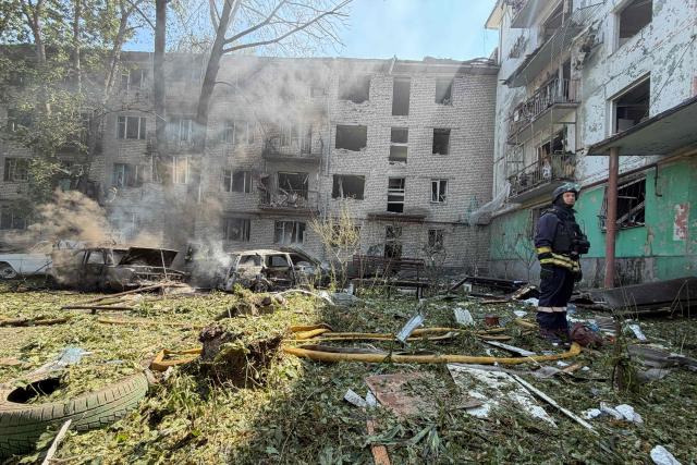 A Ukrainian rescuer stands next to a damaged residential building at the site of a Russian airstrike in Zaporizhzhia on August 10, 2026, amid the Russian invasion of Ukraine. (Photo by Darya NAZAROVA / AFP)