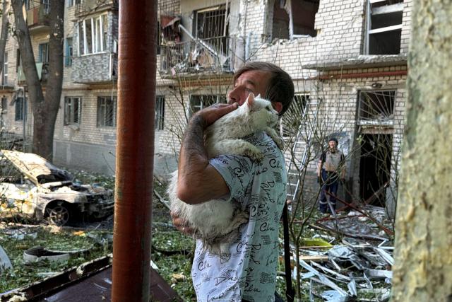 A man carries a cat next to a damaged residential building at the site of a Russian airstrike in Zaporizhzhia on August 10, 2026, amid the Russian invasion of Ukraine. (Photo by Darya NAZAROVA / AFP)