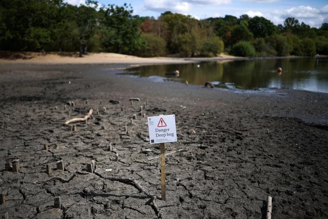 The dried and cracked bed of the depleted Hollow Pond and Leyton flats near Wanstead, east London, on August 10, 2026, is pictured following weeks of hot, dry weather, leading to more than half of England being declared to be in a drought. (Photo by HENRY NICHOLLS / AFP)