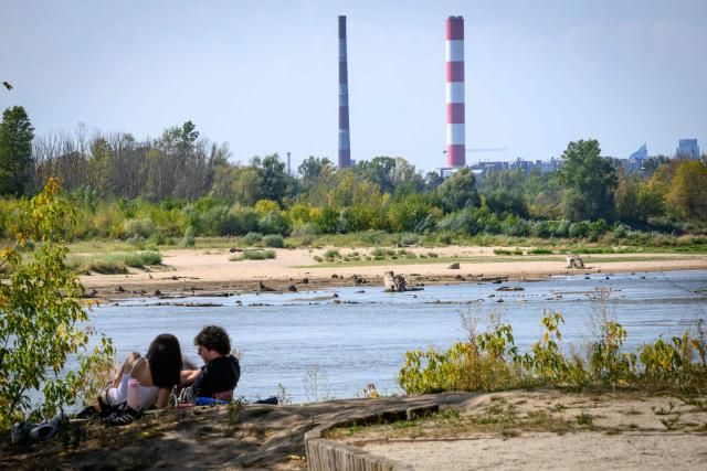 People enjoy a beach on the Vistula river just outside the capital Warsaw on August 10, 2026. The Vistula, Poland's longest river, fell on Monday to match its record low in Warsaw, the national meteorological institute IMGW reported, with Europe sweltering through multiple heatwaves. (Photo by Mladen ANTONOV / AFP)