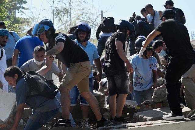 People work on a collapsed building after an earthquake in Cali, Colombia on August 10, 2026. A powerful earthquake rocked Colombia and neighboring Latin American countries on August 10, 2026, with medical teams rushing to help victims after buildings were damaged or collapsed in several cities. The Colombian geological service and its American counterpart USGS put the magnitude at 7.4, with an epicenter 100 km (60 miles) underground in the west of the country. Colombia had initially put it at 6.6. (Photo by Joaquin SARMIENTO / AFP)