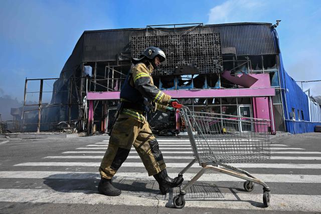 Firefighters work on the grounds of a burned DIY and construction materials mall following an overnight attack, which local Russian-installed officials called Ukrainian drone strikes, in Makiivka (Makeyevka) in the Donetsk region, Russian-controlled Ukraine, on August 10, 2026, amid the ongoing Russian-Ukrainian conflict. (Photo by AFP)