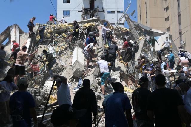 People look for survivors amid the rubble of a collapsed building after an earthquake in Cali, Colombia, on August 10, 2026. A powerful earthquake rocked Colombia and neighboring Latin American countries on August 10, 2026, with medical teams rushing to help victims after buildings were damaged or collapsed in several cities. The Colombian geological service and its American counterpart USGS put the magnitude at 7.4, with an epicenter 100 km (60 miles) underground in the west of the country. Colombia had initially put it at 6.6. (Photo by Joaquín SARMIENTO / AFP)