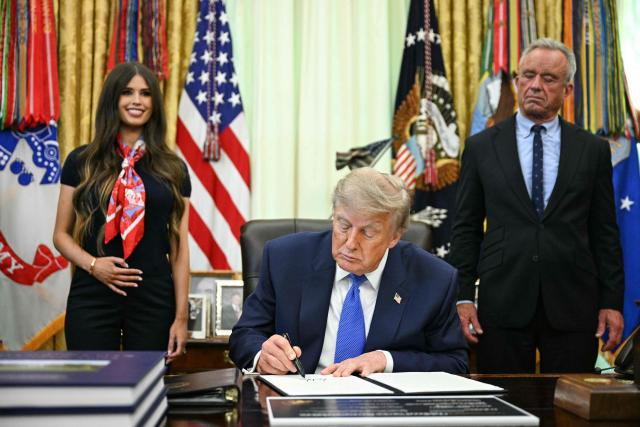 US President Donald Trump signs an executive order calling for more research and flexibility on vaccines, alongside US Secretary of Health and Human Services Robert F. Kennedy Jr. (R) and Jayme Leagh Franklin (L), founder of The Conservateur, in the Oval Office of the White House in Washington, DC, on August 10, 2026. (Photo by Jim WATSON / AFP)