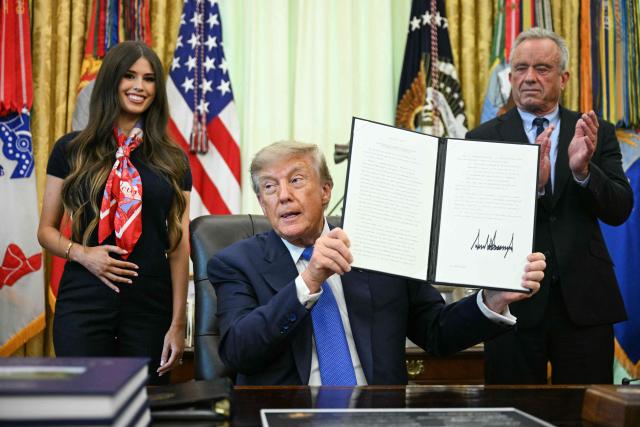 US President Donald Trump signs an executive order calling for more research and flexibility on vaccines, alongside US Secretary of Health and Human Services Robert F. Kennedy Jr. (R) and Jayme Leagh Franklin (L), founder of The Conservateur, in the Oval Office of the White House in Washington, DC, on August 10, 2026. (Photo by Jim WATSON / AFP)