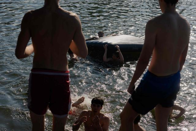 Teenagers swim in Telbin lake on a hot day in Kyiv on August 10, 2026, amid the Russian invasion of Ukraine. (Photo by Tetiana DZHAFAROVA / AFP)