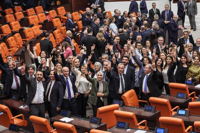 Equality and Democracy (DEM) Party law makers make the victory sign after voting a bill offering limited amnesty for Kurdish PKK militants at Grand National Assembly of Turkey in Ankara on August 10, 2026. Turkish lawmakers on August 10, 2026, voted through a bill offering limited amnesty for Kurdish PKK militants in a first legislative step to end decades of deadly violence, footage from parliament showed. The bill offering limited amnesty to Kurdish fighters remained silent on the fate of jailed PKK leader Abdullah Ocalan, who championed the process. (Photo by Adem ALTAN / AFP)