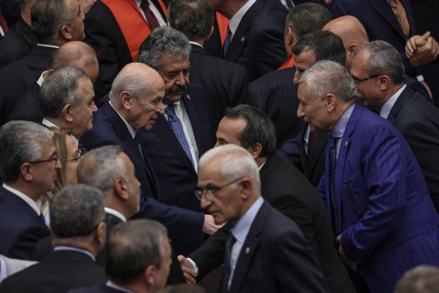 Turkish Nationalist Movement Party's (MHP) leader Devlet Bahceli (C-L) shakes hands with Equality and Democracy (DEM) Party lawmakers after voting a bill offering limited amnesty for Kurdish PKK militants at Grand National Assembly of Turkey in Ankara on August 10, 2026. Turkish lawmakers on August 10, 2026, voted through a bill offering limited amnesty for Kurdish PKK militants in a first legislative step to end decades of deadly violence, footage from parliament showed. The bill offering limited amnesty to Kurdish fighters remained silent on the fate of jailed PKK leader Abdullah Ocalan, who championed the process. (Photo by Adem ALTAN / AFP)