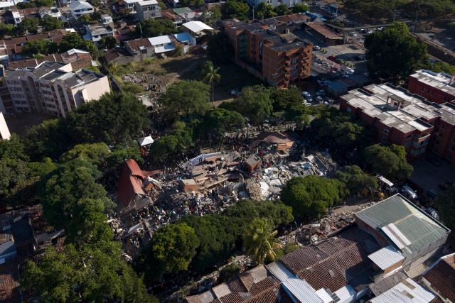 This aerial view shows a collapsed building after an earthquake in Cali, Colombia on August 10, 2026. A magnitude 7.4 earthquake struck Colombia on August 10, 2026, and killed at least 111 people, damaged more than 1,500 buildings, and left an unknown number of people buried under rubble. The government declared a state of emergency to attend to the quake that shook several cities across the coffee-producing region, the Pacific coast, and neighboring Latin American countries, sending terrified residents racing into the street. (Photo by Joaquín SARMIENTO / AFP)