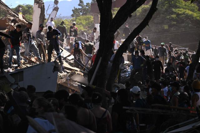 People and rescuers look for survivors amid the rubble of a collapsed building after an earthquake in Cali, Colombia on August 10, 2026. A magnitude 7.4 earthquake struck Colombia on August 10, 2026, and killed at least 111 people, damaged more than 1,500 buildings, and left an unknown number of people buried under rubble. The government declared a state of emergency to attend to the quake that shook several cities across the coffee-producing region, the Pacific coast, and neighboring Latin American countries, sending terrified residents racing into the street. (Photo by Joaquin SARMIENTO / AFP)