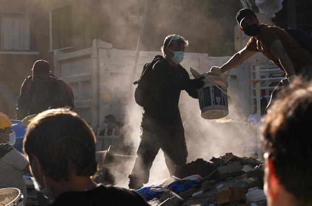 People remove rubble from a collapsed building after an earthquake in Cali, Colombia on August 10, 2026. A magnitude 7.4 earthquake struck Colombia on August 10, 2026, and killed at least 111 people, damaged more than 1,500 buildings, and left an unknown number of people buried under rubble. The government declared a state of emergency to attend to the quake that shook several cities across the coffee-producing region, the Pacific coast, and neighboring Latin American countries, sending terrified residents racing into the street. (Photo by Joaquin SARMIENTO / AFP)