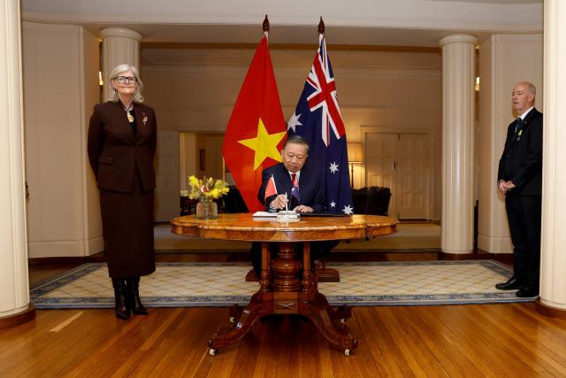 Vietnamese General Secretary and President To Lam signs a visitors' book as Australia's Governor-General Sam Mostyn (L) looks on at Government House in Canberra on August 11, 2026. (Photo by hilary wardhaugh / AFP)