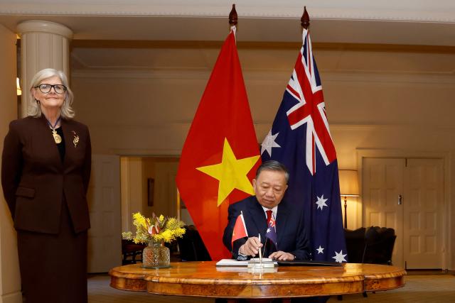 Vietnamese General Secretary and President To Lam signs a visitors' book as Australia's Governor-General Sam Mostyn (L) looks on at Government House in Canberra on August 11, 2026. (Photo by hilary wardhaugh / AFP)