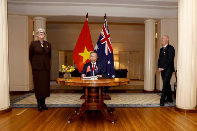Vietnamese General Secretary and President To Lam waits to sign a visitors' book as Australia's Governor-General Sam Mostyn (L) looks on at Government House in Canberra on August 11, 2026. (Photo by hilary wardhaugh / AFP)