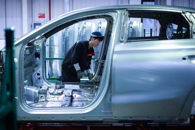 An employee works on a production line assembling methanol plug-in hybrid sedans at a Geely plant in Shenyang, northeastern China's Liaoning province on August 10, 2026. (Photo by CN-STR / AFP) / China OUT