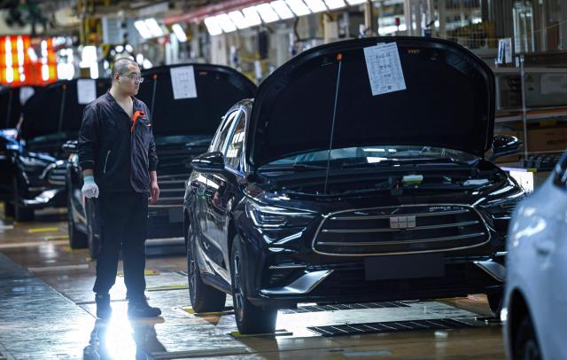 An employee works on a production line assembling methanol plug-in hybrid sedans at a Geely plant in Shenyang, northeastern China's Liaoning province on August 10, 2026. (Photo by CN-STR / AFP) / China OUT