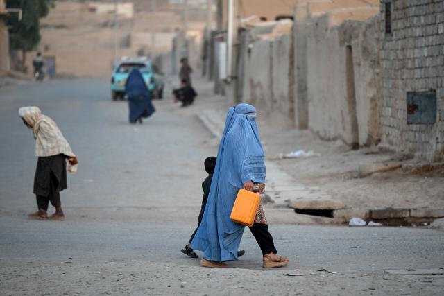 An Afghan burqa-clad woman walks along a street in the 7th district of Afghanistan's Kandahar on August 11, 2026. (Photo by Sanaullah SEIAM / AFP)