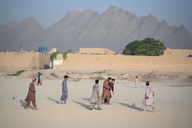 Afghan young men play football a ground in Dand district of Afghanistan's Kandahar on August 11, 2026. (Photo by Sanaullah SEIAM / AFP)