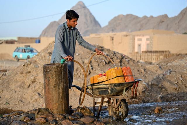 An Afghan man fills canisters with drinking water from a public water pump in the Dand district of Afghanistan's Kandahar on August 11, 2026. (Photo by Sanaullah SEIAM / AFP)