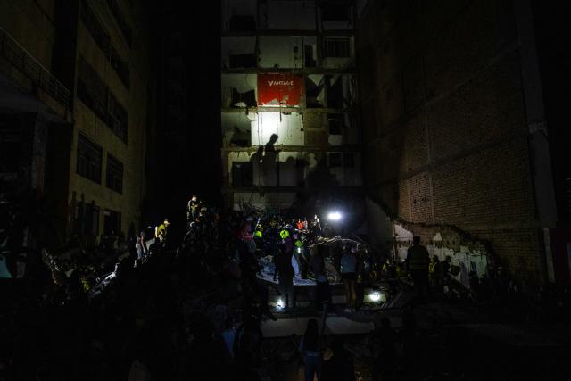 Rescuers are joined by local residents to clear the rubble while searching for survivors at a collapsed building after an earthquake in Pereira, Colombia, on August 10, 2026. A magnitude 7.4 earthquake struck Colombia on August 10, 2026, and killed at least 111 people, damaged more than 1,500 buildings, and left an unknown number of people buried under rubble. The government declared a state of emergency to attend to the quake that shook several cities across the coffee-producing region, the Pacific coast, and neighboring Latin American countries, sending terrified residents racing into the street. (Photo by Luis ACOSTA / AFP)