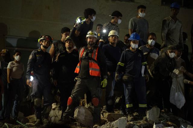 Rescuers look for survivors amid the rubble of a collapsed building after an earthquake in Pereira, Colombia, on August 10, 2026. A magnitude 7.4 earthquake struck Colombia on August 10, 2026, and killed at least 111 people, damaged more than 1,500 buildings, and left an unknown number of people buried under rubble. The government declared a state of emergency to attend to the quake that shook several cities across the coffee-producing region, the Pacific coast, and neighboring Latin American countries, sending terrified residents racing into the street. (Photo by Luis ACOSTA / AFP)