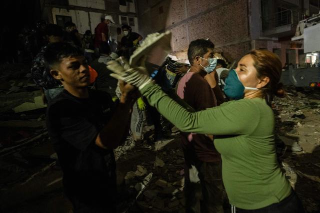 People help rescuers search for survivors at a collapsed building after an earthquake in Pereira, Colombia, on August 10, 2026. A magnitude 7.4 earthquake struck Colombia on August 10, 2026, and killed at least 111 people, damaged more than 1,500 buildings, and left an unknown number of people buried under rubble. The government declared a state of emergency to attend to the quake that shook several cities across the coffee-producing region, the Pacific coast, and neighboring Latin American countries, sending terrified residents racing into the street. (Photo by Luis ACOSTA / AFP)