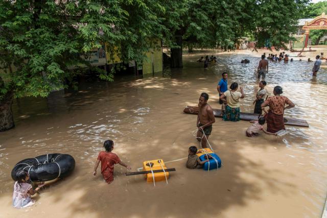People wade through a flooded area due to monsoon rains and rising river water levels in Wetlet, Myanmar’s Sagaing region on August 10, 2026. (Photo by AFP)