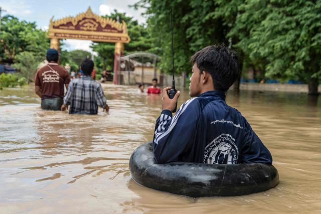 People wade through a flooded area due to monsoon rains and rising river water levels in Wetlet, Myanmar’s Sagaing region on August 10, 2026. (Photo by AFP)