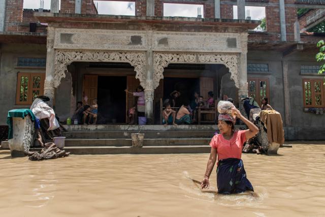 A woman wades through a flooded area due to monsoon rains and rising river water levels in Wetlet, Myanmar’s Sagaing region on August 10, 2026. (Photo by AFP)