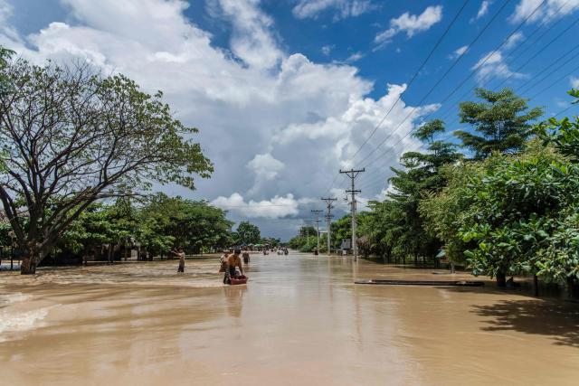People wade through a flooded area due to monsoon rains and rising river water levels in Wetlet, Myanmar’s Sagaing region on August 10, 2026. (Photo by AFP)