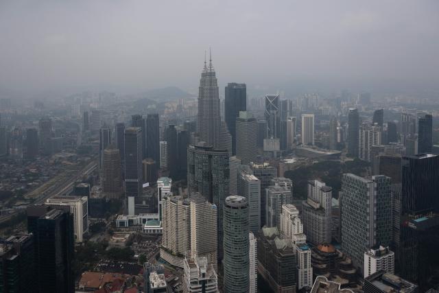The Petronas Twin Towers (C) are covered in haze in Kuala Lumpur on August 11, 2026, as authorities in Malaysia warned of high levels of air pollution from regional wildfires. The Malaysian Meteorological Department urged people on August 11 affected by air pollution to stay indoors, with director-general Mohd Hisham Mohd Anip blaming a "cross-border haze phenomenon from Kalimantan," the Indonesian portion of the island of Borneo. (Photo by Mohd Rasfan / AFP)