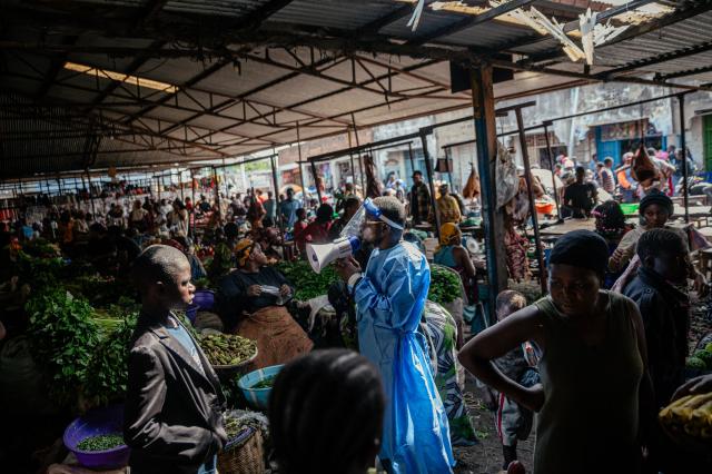 (FILES) Irenge Biringanine Prince, leader of the U Report Goma community, dressed in protective equipment, raises awareness among traders alongside young members of the “U Report Goma” group who continue awareness activities at Alanine market using megaphones and focus group discussions as part of Ebola prevention and awareness measures in Goma, on May 29, 2026. An Ebola outbreak in the Democratic Republic of Congo has killed 2,011 people out of 4,381 confirmed cases of the virus, Congolese officials said on Tuesday.
The latest toll for the disease, which has hit the DRC's conflict-plagued eastern and northeastern regions, puts it close behind the country's deadliest Ebola outbreak in 2018 to 2020 when nearly 2,300 people died. (Photo by Jospin Mwisha / AFP)