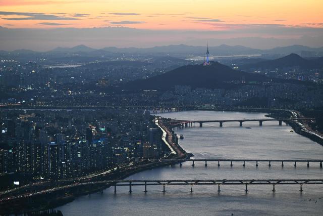 The Han river and the Seoul Tower (top) are seen from the Lotte World Tower at dusk in Seoul on August 11, 2026. (Photo by GREG BAKER / AFP)