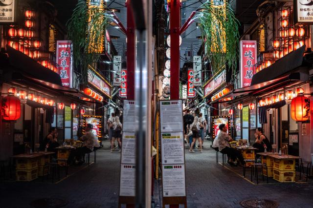 Pedestrians and diners visit a street in Shinjuku district in Tokyo on August 11, 2026. (Photo by Philip FONG / AFP)