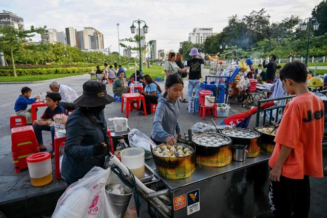 Vendor prepare coconut rice pancakes for customers at Wat Botum park in Phnom Penh on August 11, 2026.  (Photo by TANG CHHIN Sothy / AFP)