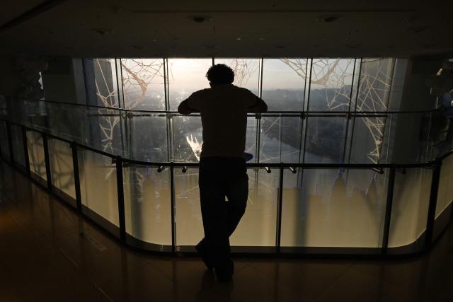A man looks at views across the city from the Lotte World Tower in Seoul on August 11, 2026. (Photo by GREG BAKER / AFP)