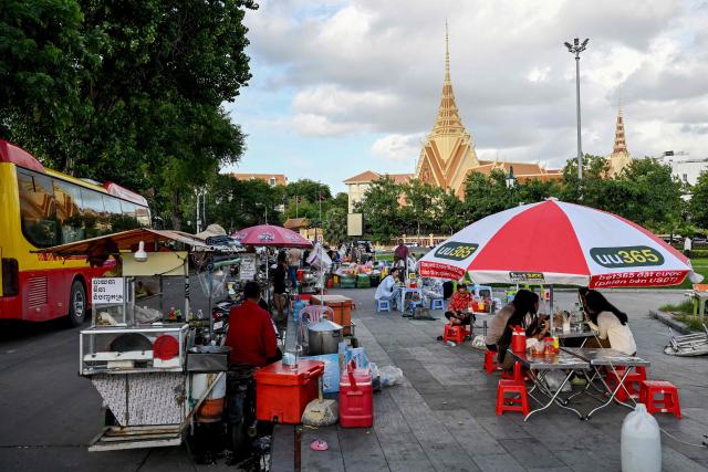 People eat food at Wat Botum park in Phnom Penh on August 11, 2026.  (Photo by TANG CHHIN Sothy / AFP)