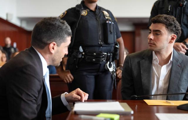 Luigi Mangione (R), accused of the murder of United Healthcare CEO Brian Thompson, speaks with one of his attorneys as he appears for a pre-trial hearing at Manhattan Criminal Court in New York, on August 11, 2026. (Photo by Barry Williams / POOL / AFP)