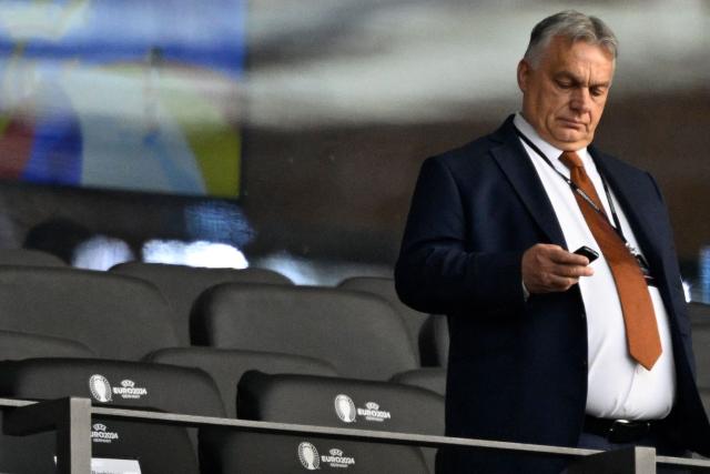 (FILES) Hungary's then Prime Minister Viktor Orban uses his phone ahead of the UEFA Euro 2024 final football match between Spain and England at the Olympiastadion in Berlin on July 14, 2024. Hungary on August 11, 2026 filed a criminal complaint over millions of euros of public funds spent under former prime minister Viktor Orban on his social media communication. The move is one of the most direct so far targeting Orban's inner circle since pro-EU Prime Minister Peter Magyar won April 2026 elections on promises of "system change". (Photo by INA FASSBENDER / AFP)