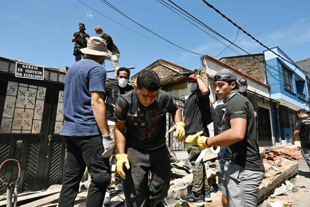 A bleeding young man leaves a collapsed house during debris cleanup efforts following an earthquake in Pereira, Colombia on August 11, 2026. Colombian volunteers and rescuers cleared rubble with their bare hands to search for survivors early on August 11 after the country's strongest earthquake in a decade killed at least 169 people and smashed dozens of buildings. (Photo by Luis ACOSTA / AFP)