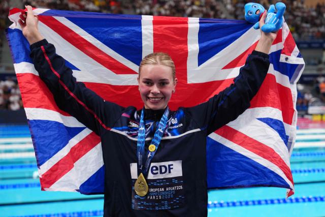 Britain's Katie Shanahan holds her national flag while posing with her gold medal after the podium ceremony of the women's 200m backstroke swimming event during the LEN European Aquatics Championships at the Olympic Aquatic Centre in Saint-Denis, northern suburbs of Paris, on August 11, 2026. (Photo by Dimitar DILKOFF / AFP)