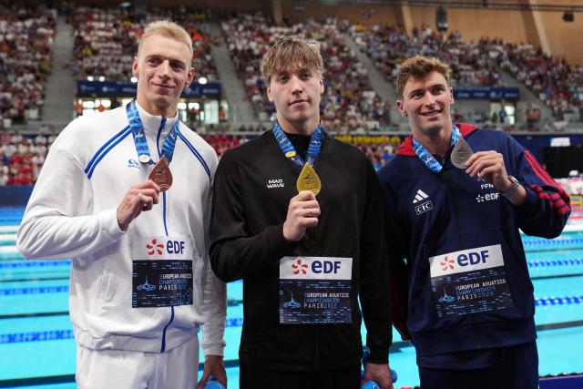 (LtoR) Neutral Athlete A's Grigori Pekarski (bronze medal), Neutral Athlete B's Egor Kornev (gold medal) and France's Maxime Grousset (silver medal) pose on the podium of the men's 50m butterfly swimming event during the LEN European Aquatics Championships at the Olympic Aquatic Centre in Saint-Denis, northern suburbs of Paris, on August 11, 2026. (Photo by Dimitar DILKOFF / AFP)