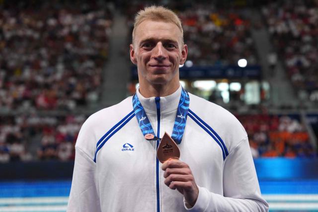 Neutral Athlete A's Grigori Pekarski poses with his bronze medal following the podium of the men's 50m butterfly swimming event during the LEN European Aquatics Championships at the Olympic Aquatic Centre in Saint-Denis, northern suburbs of Paris, on August 11, 2026. (Photo by Dimitar DILKOFF / AFP)