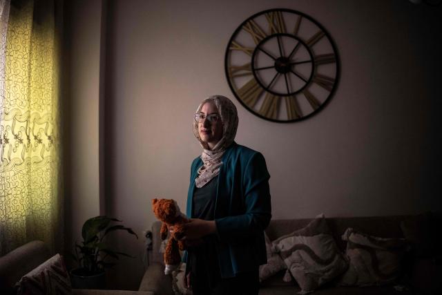 Palestinian woman Dania Abu Haikal, mother of seven-month-old Sam, who was killed by Israeli forces whilst sitting on his mother's lap in the car, stands for portrait while holding her late sons' teddy bear in Bethlehem, in the occupied West Bank, on August 7, 2026. B'Tselem, an Israeli rights group, reported 235 underage deaths at the hands of Israeli forces in the West Bank in the Palestinian territory since October 7, 2023, when Hamas launched a massive attack on Israel from the Gaza Strip, through June 2026, including five killed by Israeli settlers. The Palestinian Wall and Resistance Commission, a Palestinian government institution, reported 250 such deaths over the same time period. (Photo by JOHN WESSELS / AFP) / To go with 'Palestinian-Israel-Conflict-WestBank', REPORTAGE