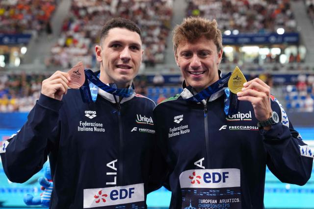 (LtoR) Italy's Simone Cerasuolo (bronze medal) and Italy's Nicolo Martinenghi (gold medal) pose on the podium of the men's 100m breaststroke swimming event during the LEN European Aquatics Championships at the Olympic Aquatic Centre in Saint-Denis, northern suburbs of Paris, on August 11, 2026. (Photo by Dimitar DILKOFF / AFP)