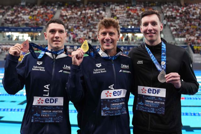 (LtoR) Italy's Simone Cerasuolo (bronze medal), Italy's Nicolo Martinenghi (gold medal) and Neutral athlete Ivan Kozhakin (silver medal) pose on the podium of the men's 100m breaststroke swimming event during the LEN European Aquatics Championships at the Olympic Aquatic Centre in Saint-Denis, northern suburbs of Paris, on August 11, 2026. (Photo by Dimitar DILKOFF / AFP)