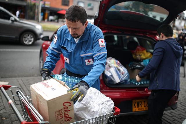 A Colombian Red Cross member gathers aid for earthquake victims in Bogota on August 11, 2026. Colombian volunteers and rescuers cleared rubble with their bare hands to search for survivors early on August 11 after the country's strongest earthquake in a decade killed at least 169 people and smashed dozens of buildings. (Photo by ESTEBAN VEGA LA-ROTTA / AFP)