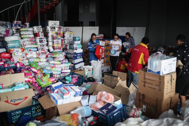 Colombian Red Cross members gather aid for earthquake victims in Bogota on August 11, 2026. Colombian volunteers and rescuers cleared rubble with their bare hands to search for survivors early on August 11 after the country's strongest earthquake in a decade killed at least 169 people and smashed dozens of buildings. (Photo by ESTEBAN VEGA LA-ROTTA / AFP)