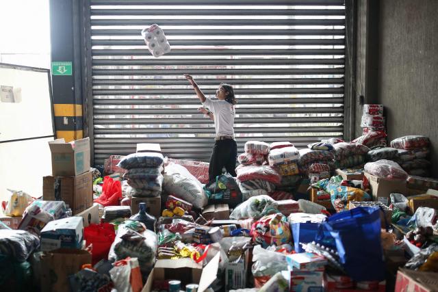 A Colombian Red Cross member gathers aid for earthquake victims in Bogota on August 11, 2026. Colombian volunteers and rescuers cleared rubble with their bare hands to search for survivors early on August 11 after the country's strongest earthquake in a decade killed at least 169 people and smashed dozens of buildings. (Photo by ESTEBAN VEGA LA-ROTTA / AFP)